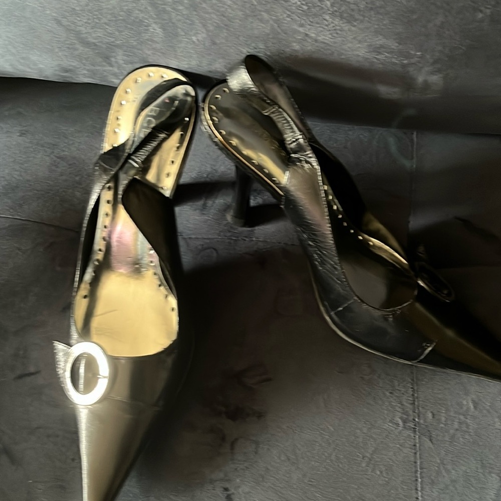 Black sling back pump with button design on top of shoe